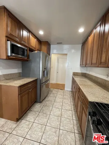 a kitchen with stainless steel appliances granite countertop a refrigerator and a sink