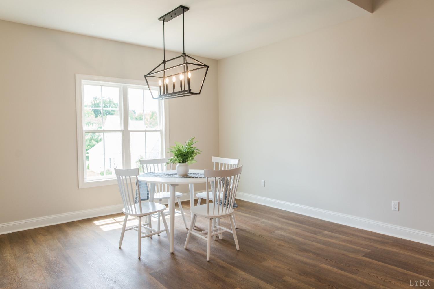 2811 Everett Road Forest, VA 24551 - Photo 49 of 49 a dining room with wooden floor a chandelier a wooden table and chairs