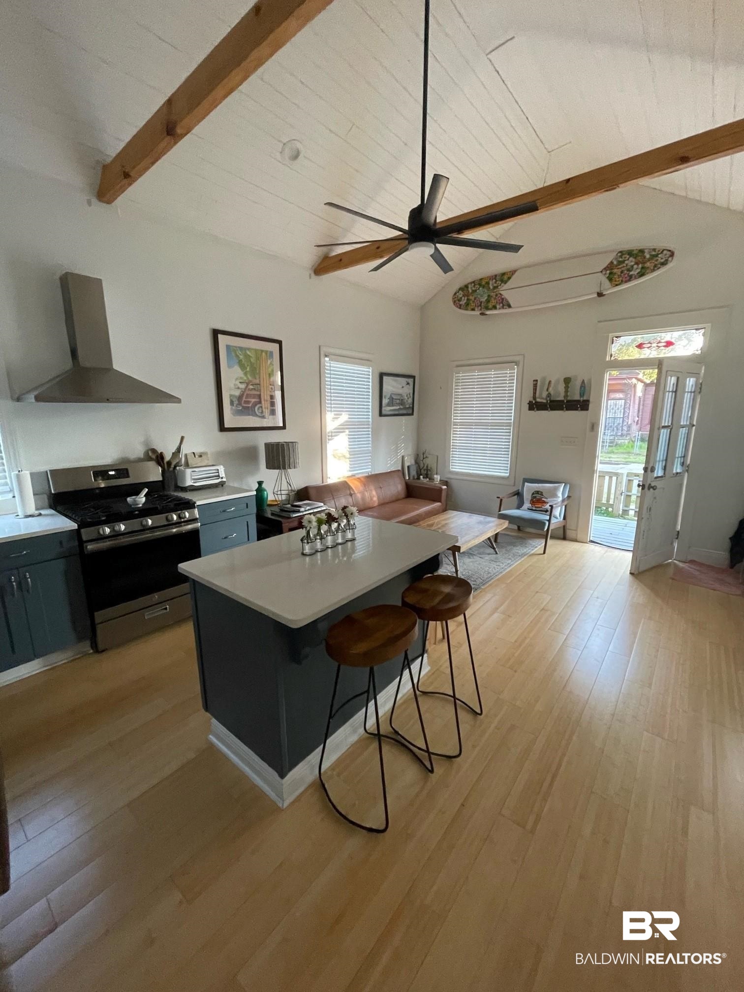 962 Savannah Street Mobile, AL 36604 - Photo 3 of 7 Kitchen with wall chimney exhaust hood, gas stove, a breakfast bar area, and light wood-type flooring