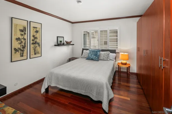 a bedroom with a bed and a painting on the wall