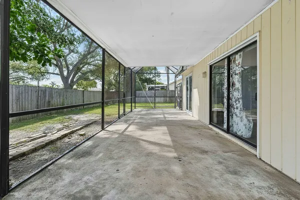 a view of backyard with large trees and wooden fence