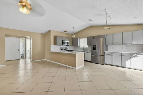 a kitchen with kitchen island granite countertop a stove a sink and a refrigerator