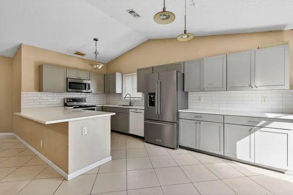 a kitchen with a sink a microwave and refrigerator