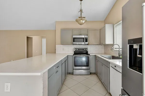 a kitchen with kitchen island granite countertop stainless steel appliances cabinets a sink and a counter top space