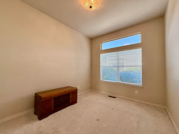 an empty room with a cabinet and mirrors
