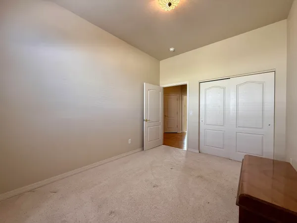 a spacious bedroom with a bed and a chandelier