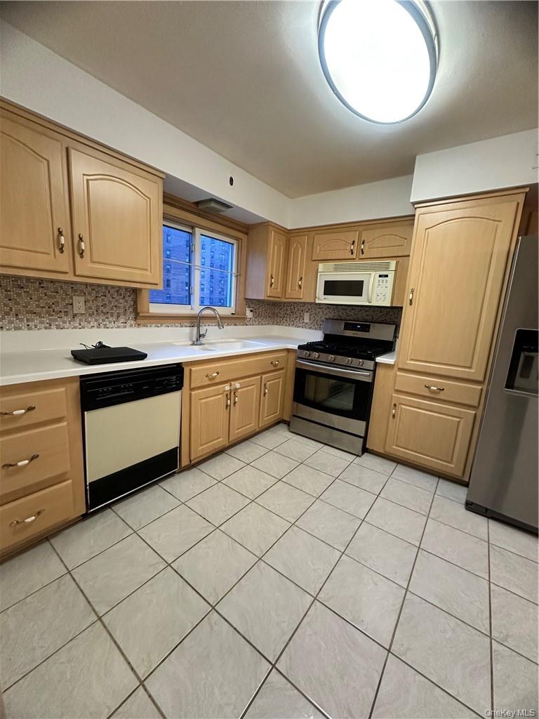545 Pelham Road New Rochelle, NY 10805 - Photo 13 of 25 a kitchen with stainless steel appliances granite countertop a sink and cabinets