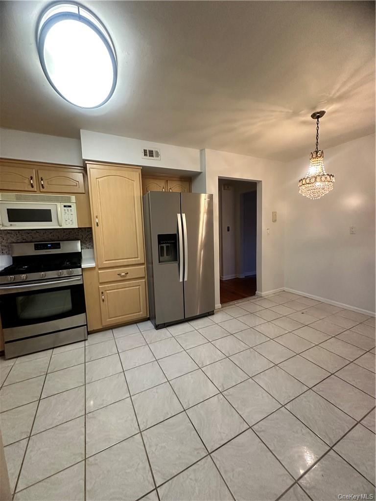 545 Pelham Road New Rochelle, NY 10805 - Photo 14 of 25 a kitchen with stainless steel appliances granite countertop a refrigerator a stove and a sink with granite countertops