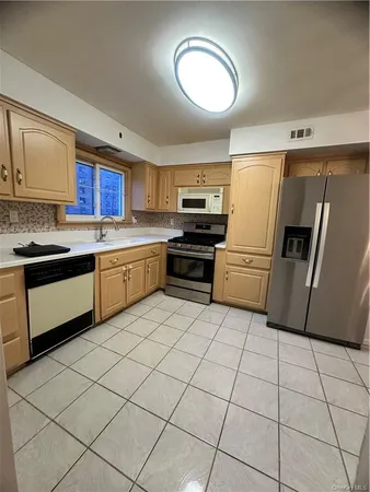 a kitchen with stainless steel appliances granite countertop a refrigerator a stove a microwave and cabinets