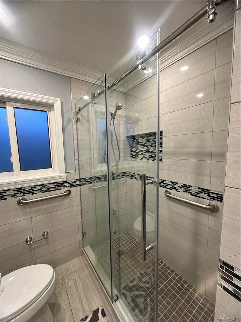 545 Pelham Road New Rochelle, NY 10805 - Photo 10 of 25 a bathroom with a shower a mirror and a sink