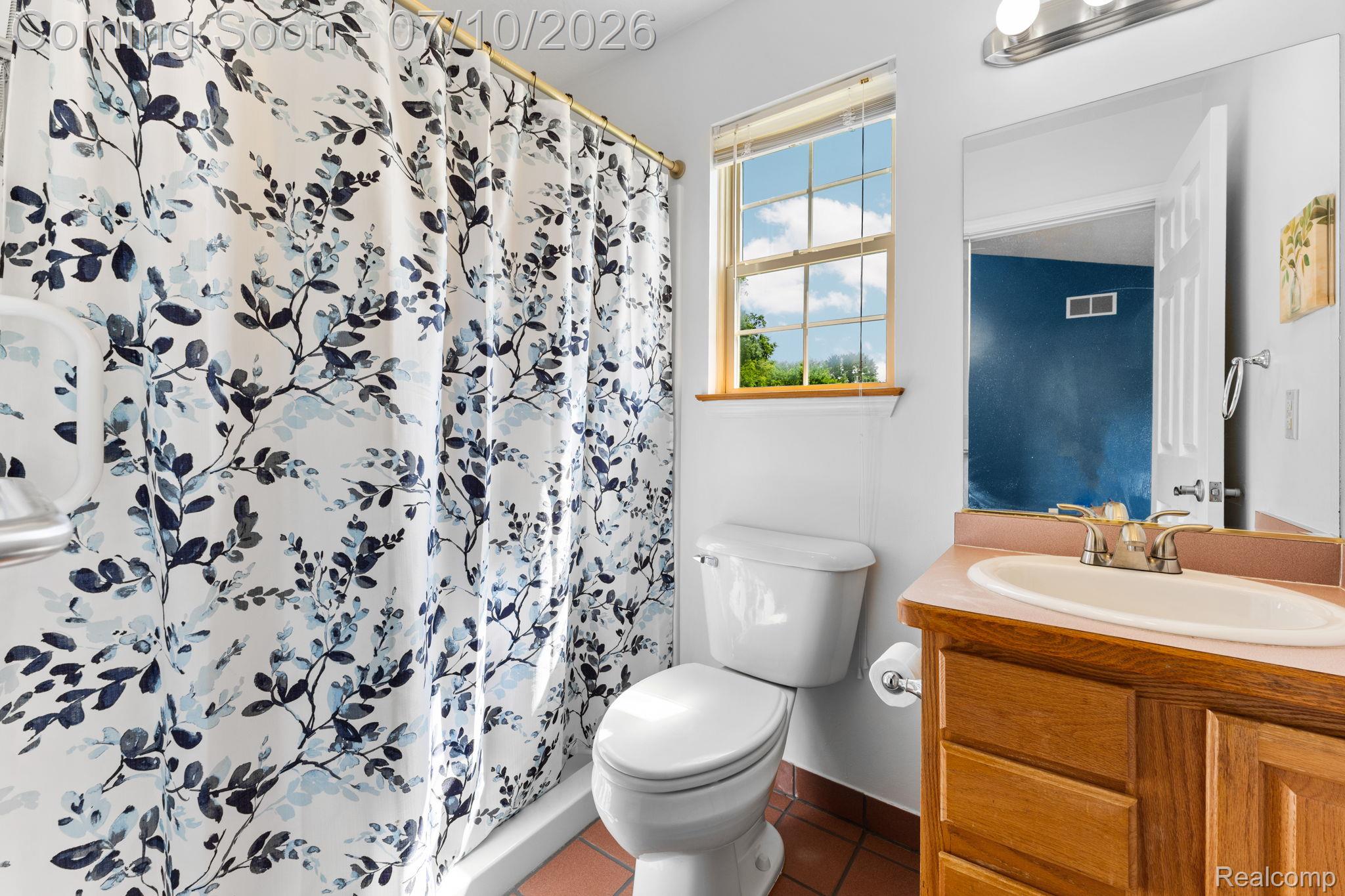 3144 North Nicholson Road Fowlerville, MI 48836 - Photo 57 of 70 Bathroom featuring a window, wood vanity with integrated sink, tile flooring, and a shower with a patterned curtain