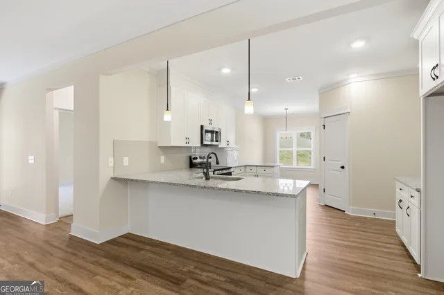 a large kitchen with a lot of counter space and wooden floor