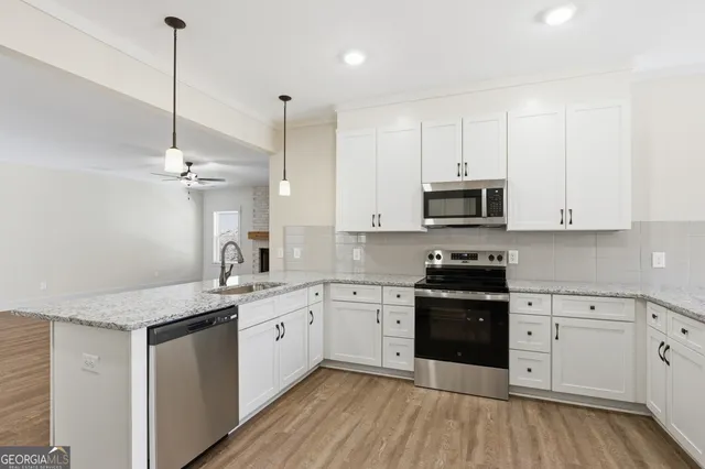 a kitchen with a sink stove and white cabinets