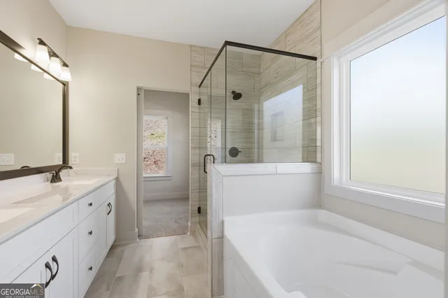 a bathroom with a tub sink and mirror
