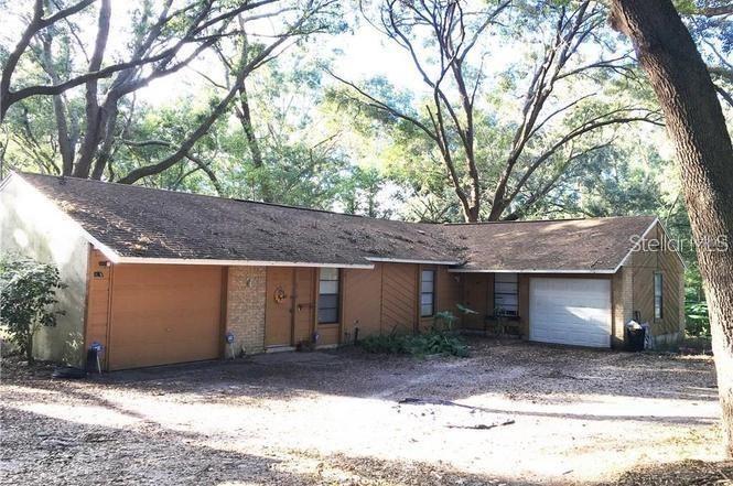 a view of a house with a yard and large tree