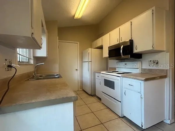 a kitchen with a stove a sink and a refrigerator