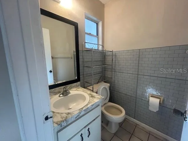 a bathroom with a granite countertop toilet sink and mirror