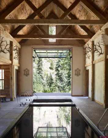 a view of backyard with swimming pool and green space