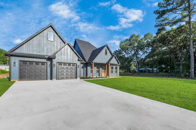 a front view of a house with a yard and trees