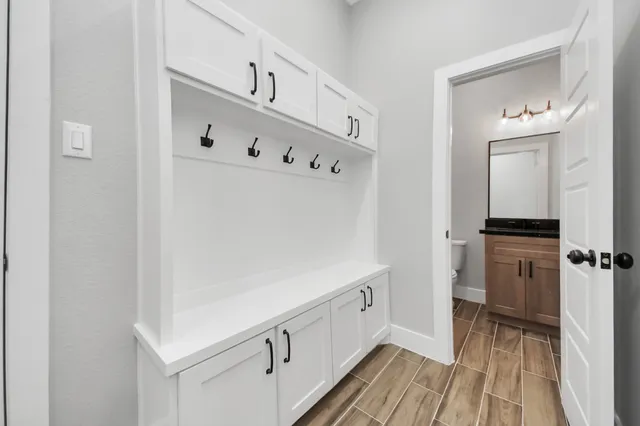 an empty room with wooden floor ceiling fan and windows