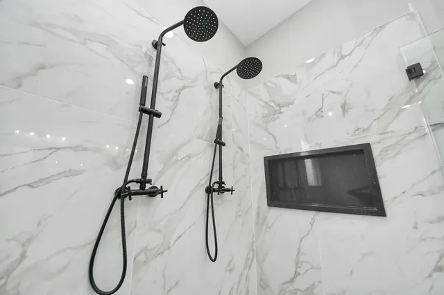 a bathroom with a granite countertop double vanity sink and mirror