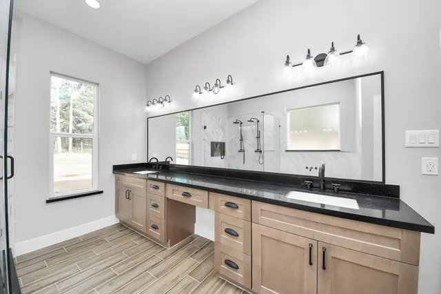 a bathroom with double vanity and a bathtub