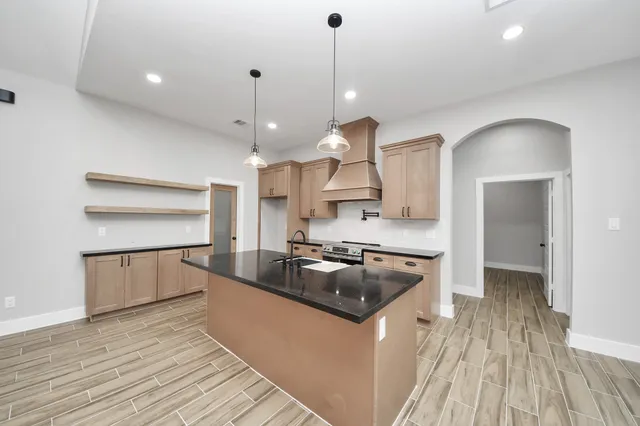 a kitchen with stainless steel appliances granite countertop a sink a stove and a refrigerator