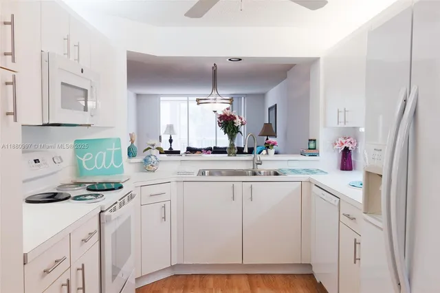 a kitchen with white cabinets and white appliances