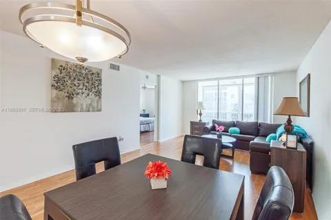 a dining room with furniture and a potted plant