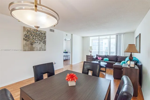 a dining room with furniture and a potted plant