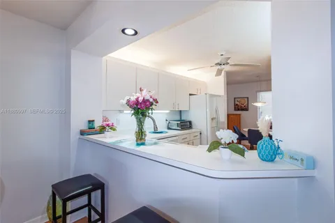 a kitchen with white cabinets and white appliances