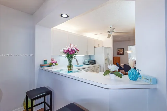a kitchen with white cabinets and white appliances