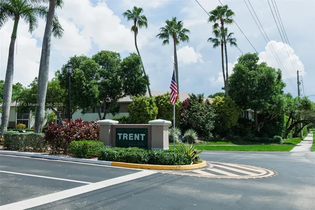 a front view of multi story residential apartment building with yard and green space