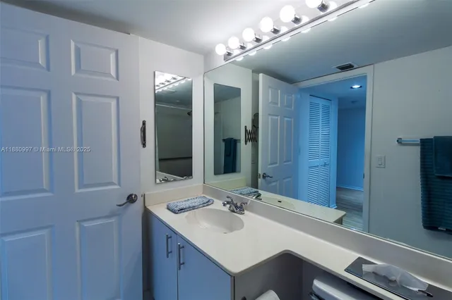 a bathroom with a sink mirror and a toilet