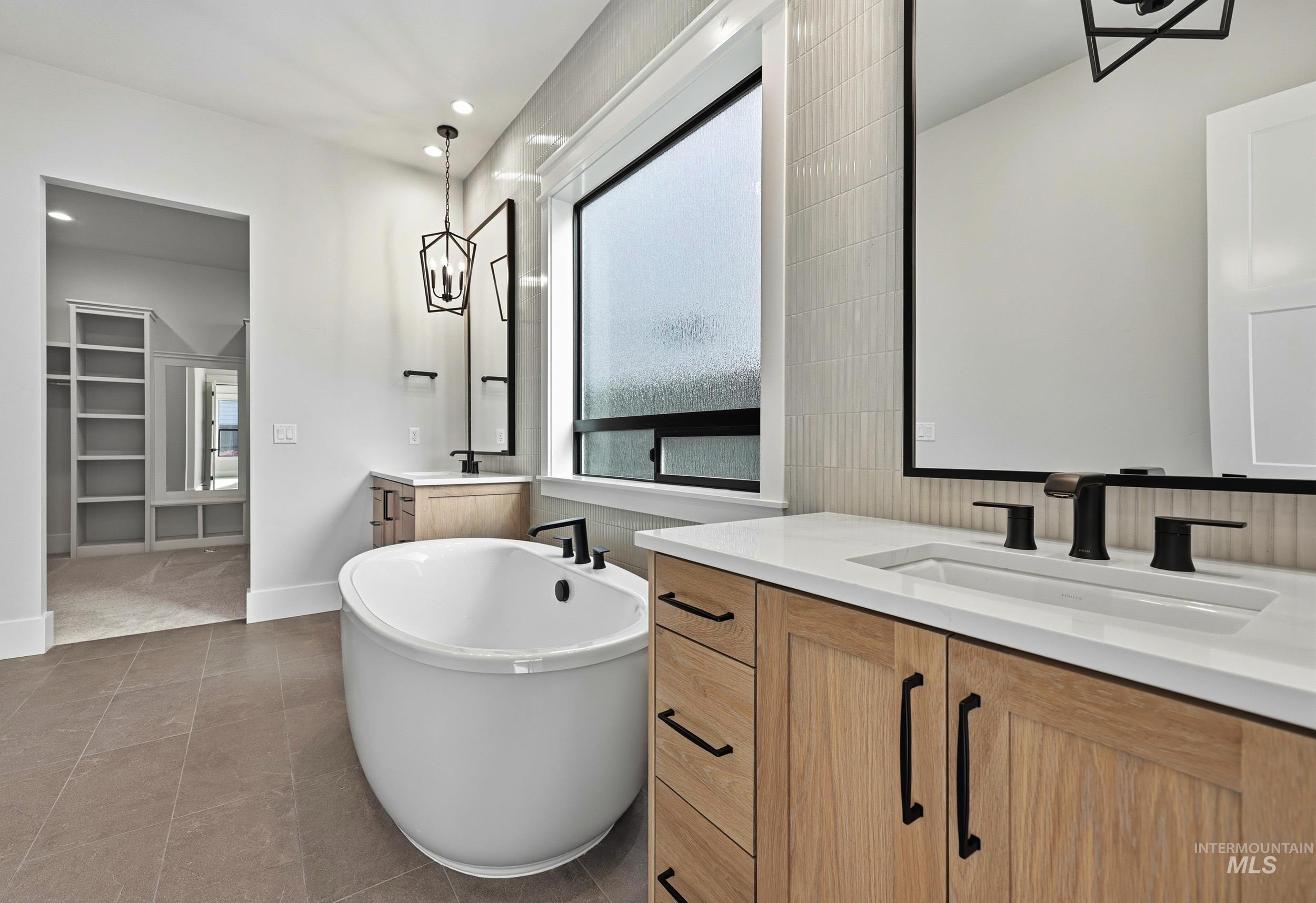 1090 East Crescendo Street Meridian, ID 83642 - Photo 16 of 43 Bathroom featuring a freestanding tub, two vanities, a walk in closet, light tile patterned floors, and recessed lighting