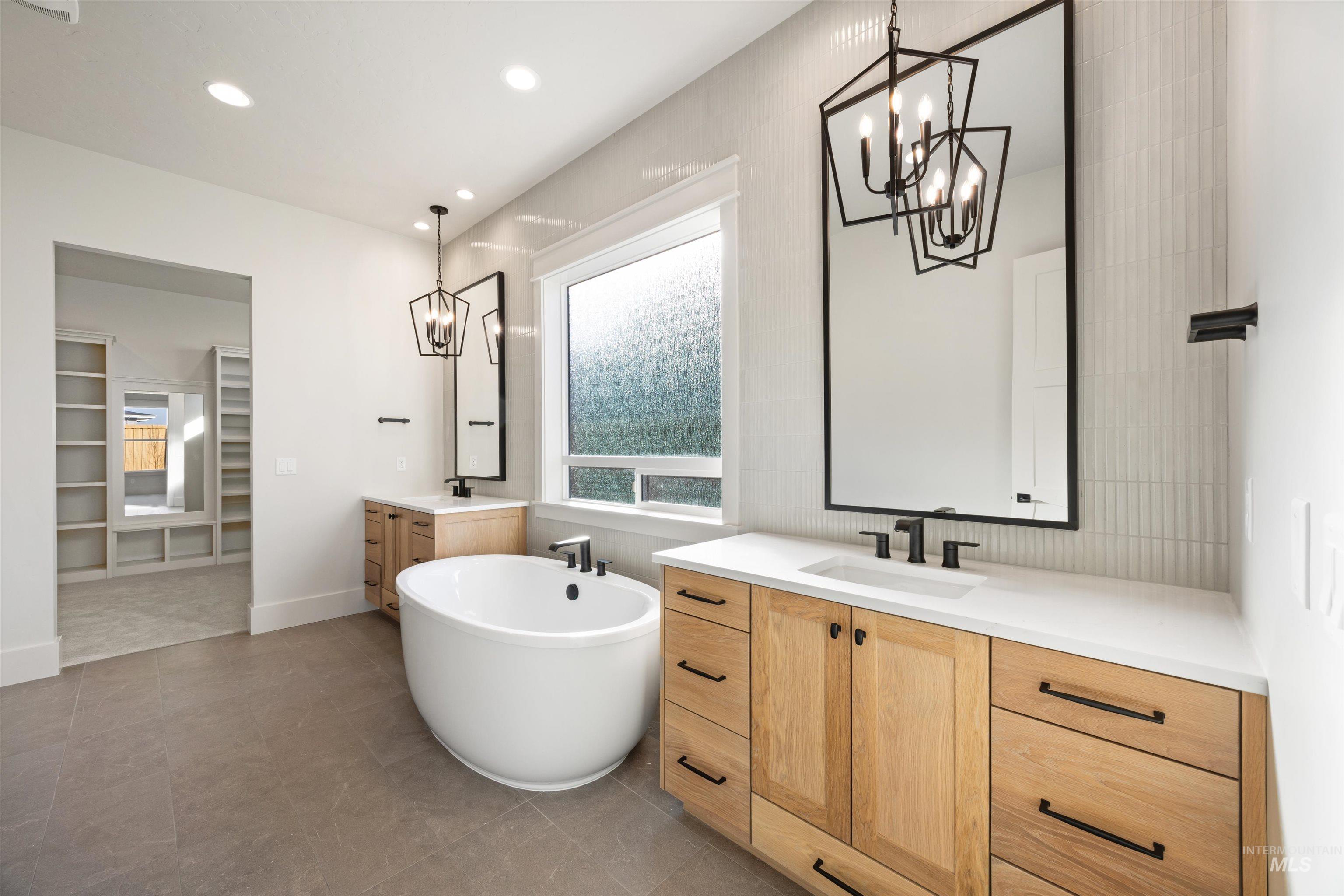 1090 East Crescendo Street Meridian, ID 83642 - Photo 28 of 50 Full bathroom with hanging lights, two vanities, a spacious closet, and a soaking tub