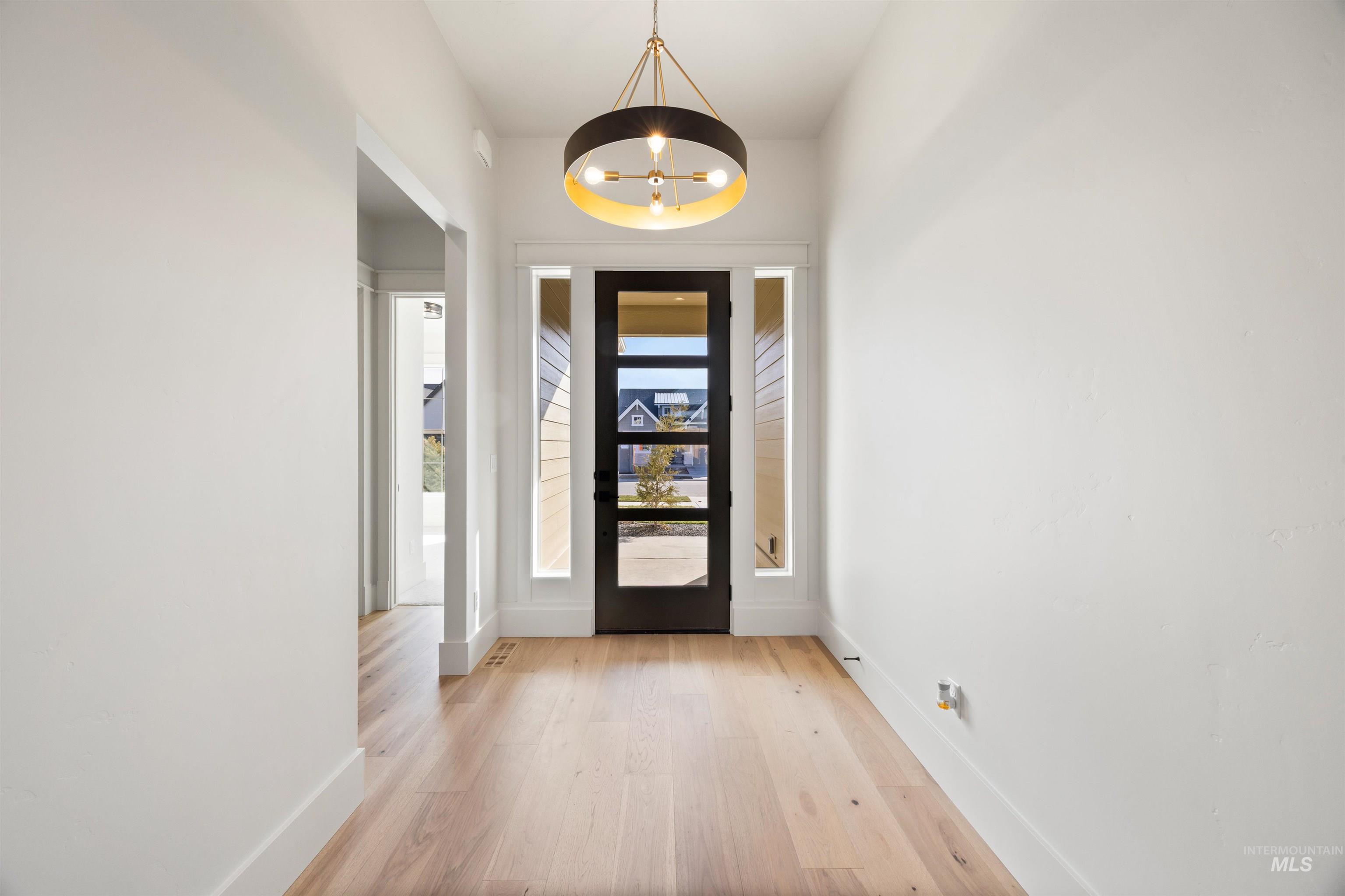 1090 East Crescendo Street Meridian, ID 83642 - Photo 3 of 50 Entryway featuring suspended lighting and light wood finished floors
