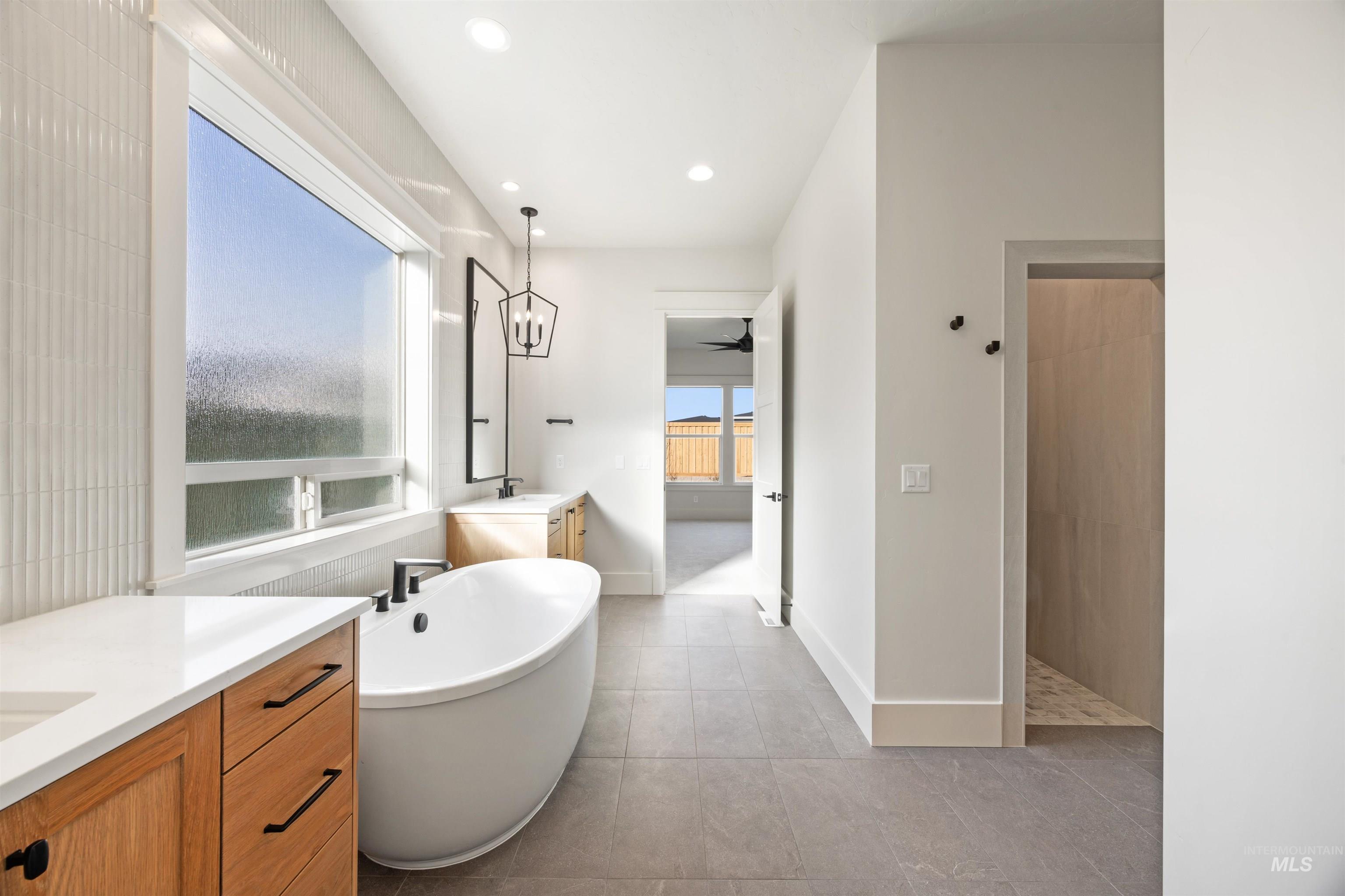 1090 East Crescendo Street Meridian, ID 83642 - Photo 31 of 50 Bathroom featuring two vanities, a freestanding bath, recessed lighting, and walk in shower
