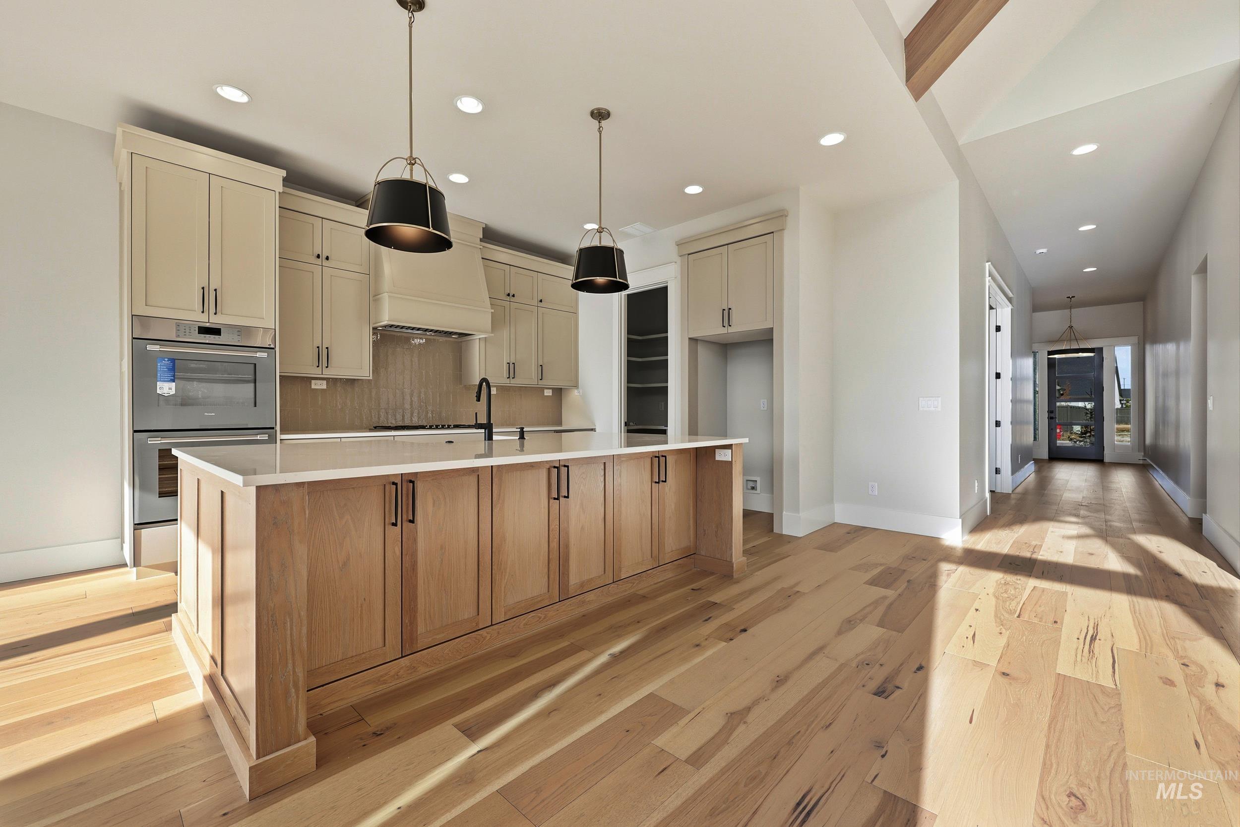 1090 East Crescendo Street Meridian, ID 83642 - Photo 5 of 43 Kitchen with decorative backsplash, stainless steel double oven, hanging light fixtures, recessed lighting, and light wood-style floors