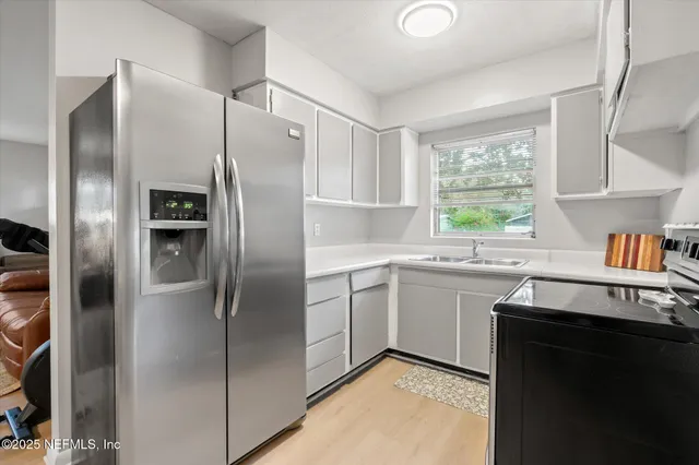 a kitchen with stainless steel appliances granite countertop a refrigerator and a sink