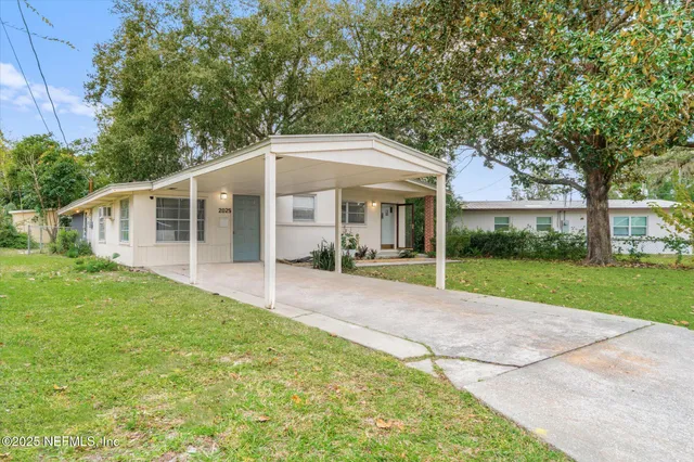 a view of a house with backyard and sitting area