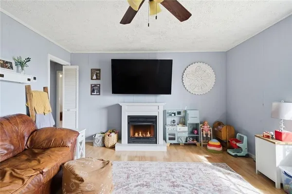 a living room with furniture a flat screen tv and a fireplace