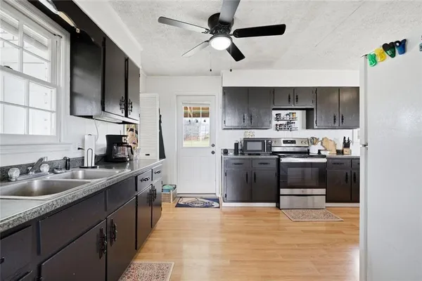 a kitchen with stainless steel appliances a stove sink microwave and cabinets