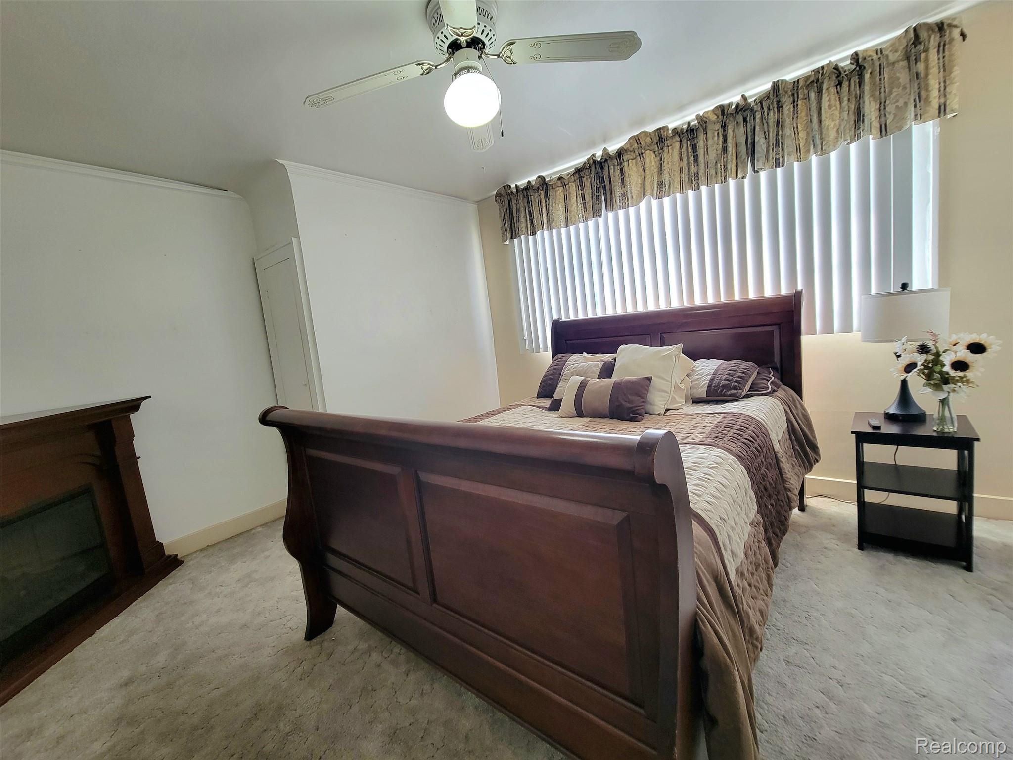 11227 Rivard Avenue Warren, MI 48089 - Photo 21 of 44 Carpeted room featuring a ceiling fan with integrated lighting, a window with vertical blinds, and a built-in decorative fireplace