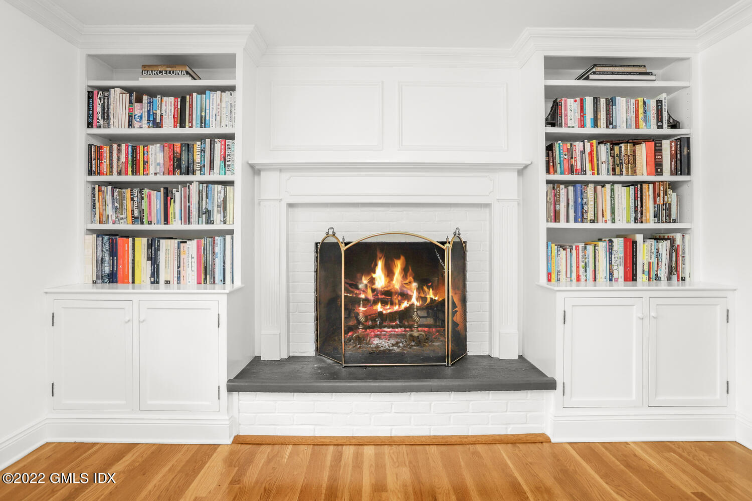 72 Lockwood Road Riverside, CT 06878 - Photo 6 of 23 a living room with bookshelf and a fireplace