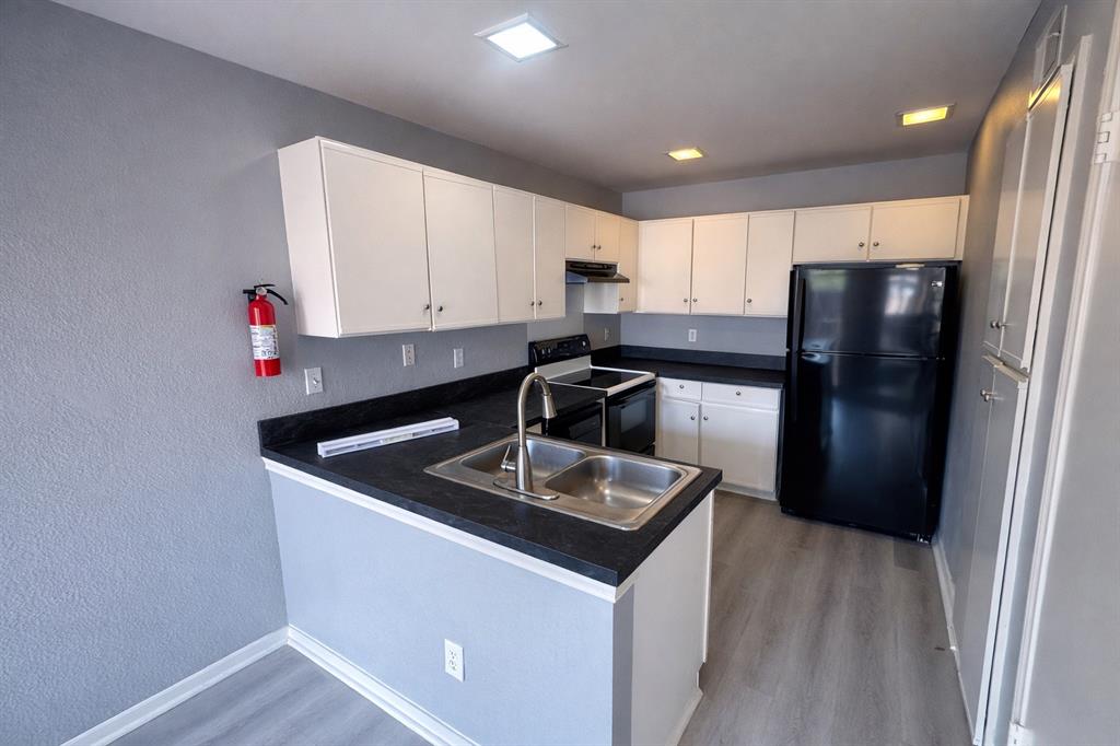 551 Ranch Trail, Unit 197 Irving, TX 75063 - Photo 5 of 14 a kitchen with stainless steel appliances granite countertop a sink stove and refrigerator