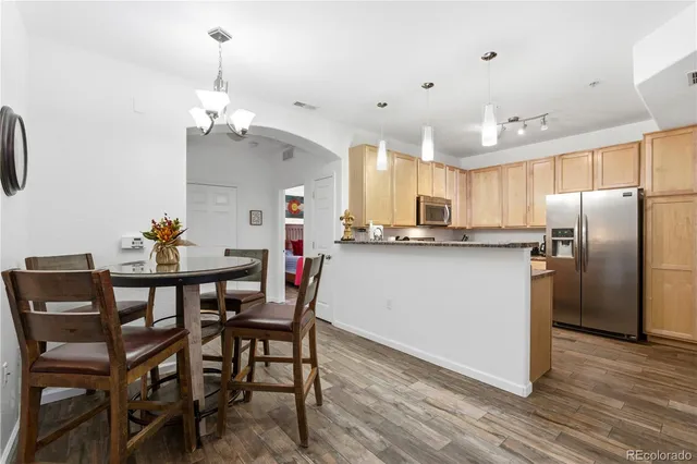 a view of a dining room with furniture a chandelier and wooden floor
