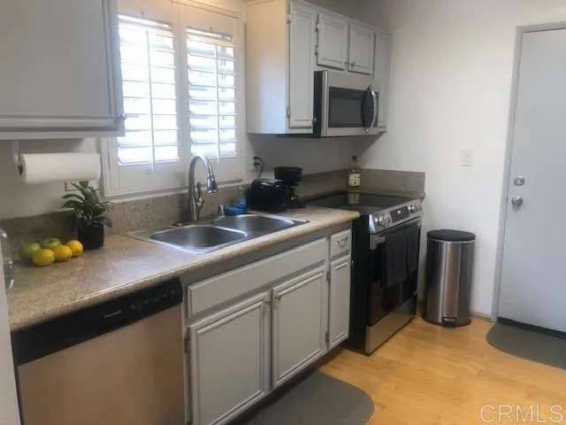 a kitchen with stainless steel appliances granite countertop a sink a stove and a granite counter tops