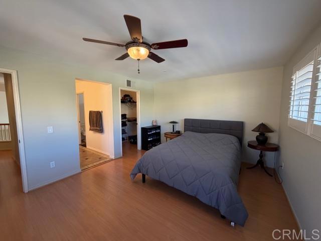 5735 Barbary Place Bonsall, CA 92003 - Photo 21 of 28 a spacious bedroom with a bed and a chandelier
