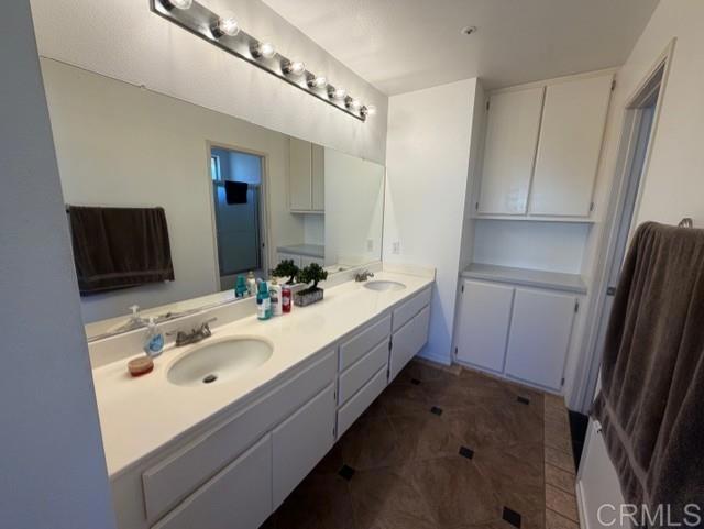 5735 Barbary Place Bonsall, CA 92003 - Photo 23 of 28 a bathroom with a sink a tub and a mirror